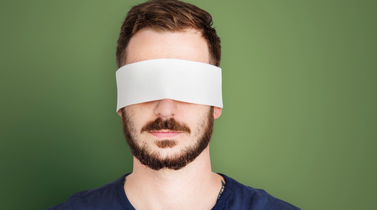 Image of man wearing a blindfold to illustrate article on gender-blind recruitment stragies