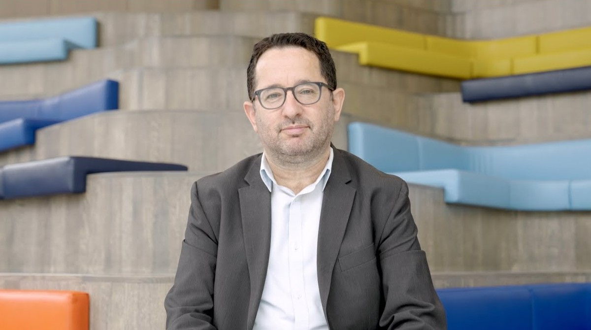Professor Oded Netzer in front of coloured wall