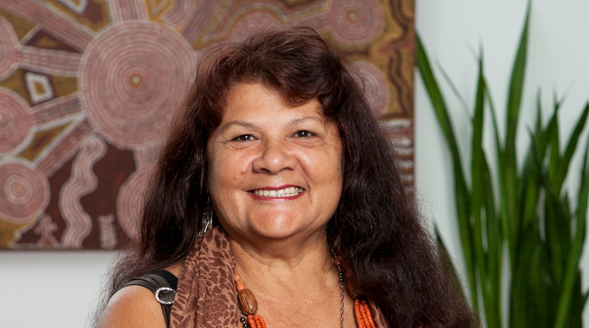 Pat Torres standing in front of indigenous art
